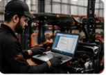 Technician running forklift diagnostics on a laptop